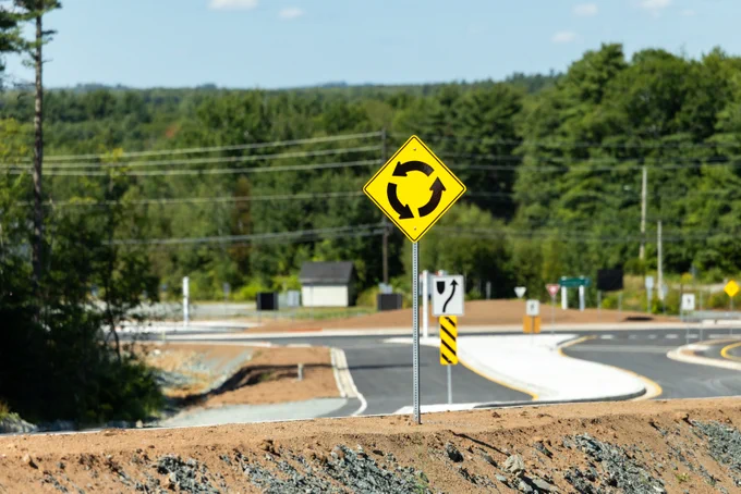 Roundabout road sign on a newly paved road