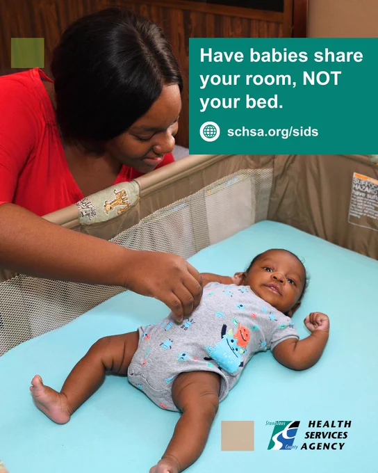 Mother checking on baby in a safe sleep crib with no objects or blankets around the baby.