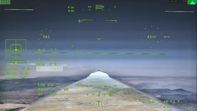 NASA’s X‑59 eXternal Vision System digital display shows green flight data overlaid on the forward scenery as the aircraft flies supersonic. Numerical indicators, horizon references, and a Mach‑number readout are visible on the screen.