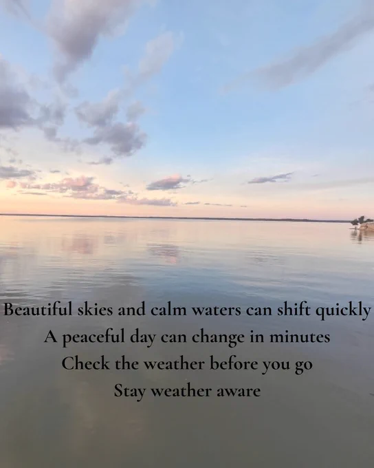 Graphic showing a calm lake at sunset with soft clouds reflected on the water. Overlaid text reads: \"Beautiful skies and calm waters can shift quickly, especially day can change in minutes. Check the weather before you go. Stay weather aware.\" The graphic reminds visitors that weather conditions on the water can change rapidly and encourages checking the forecast before heading outdoors.