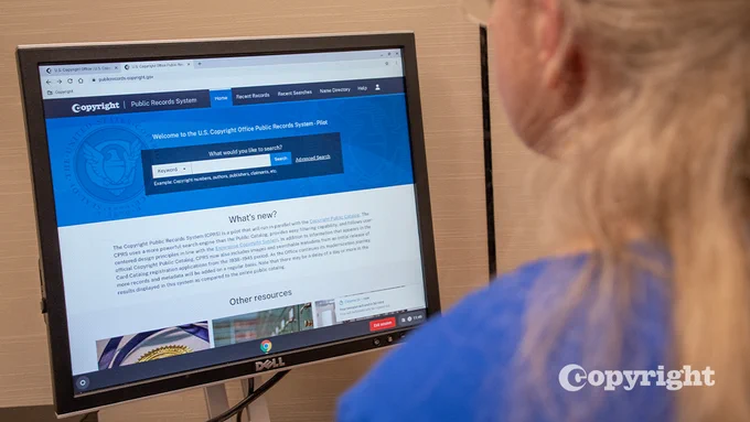 Person with blonde hair sits at a computer screen which displays the CPR webpage. 