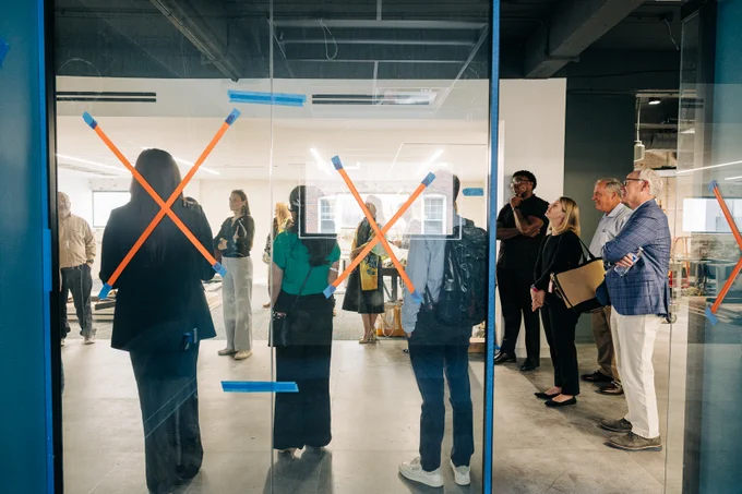 View of the Do Greater space from inside one of the co-working spaces. The windows are marked with Xs. 