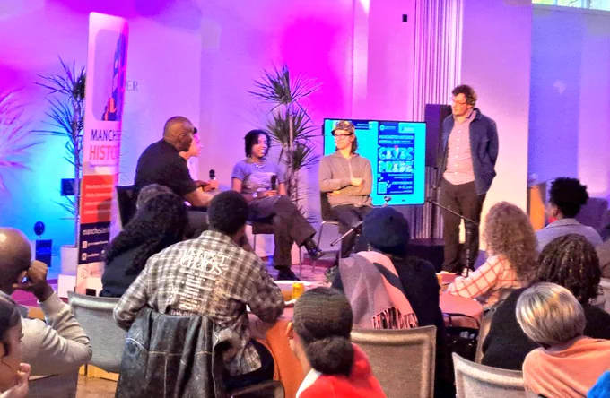 Young people on stage answers questions with seated audience 