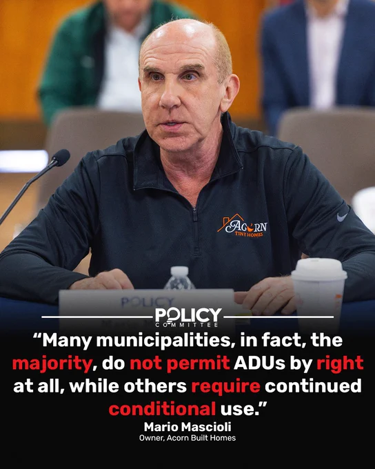 Mario Mascioli, Owner of Acorn Built Homes, speaks at a Policy Committee hearing with quote overlay.