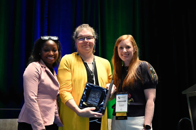 Kirsten Clemens, EGLE’s scrap tire coordinator (center),
receives an award from the Tire Recycling Foundation for the department’s scrap tire market development efforts.