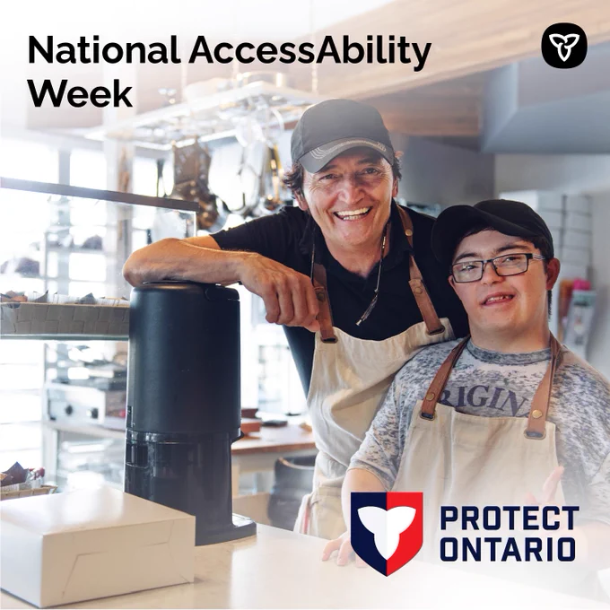 A person and another person posing behind a counter at a cafe. Text reads: National AccessAbility Week