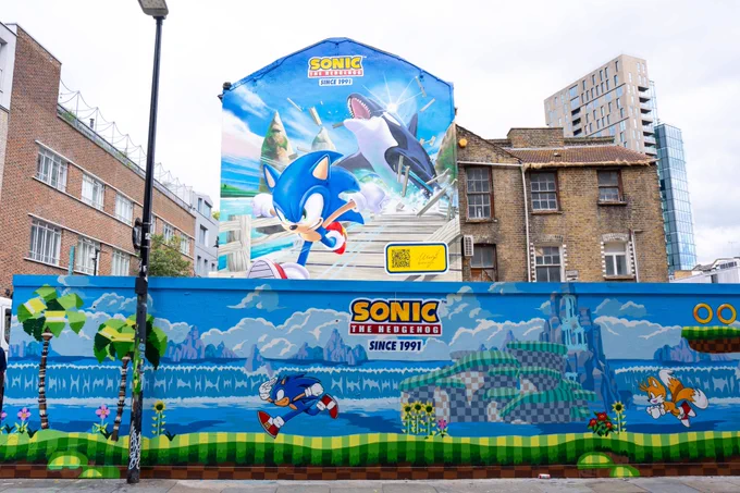Sonic the Hedgehog mural based on Green Hill Zone. Above it is another mural of Sonic the Hedgehog depicting the whale chase from Sonic Adventure.