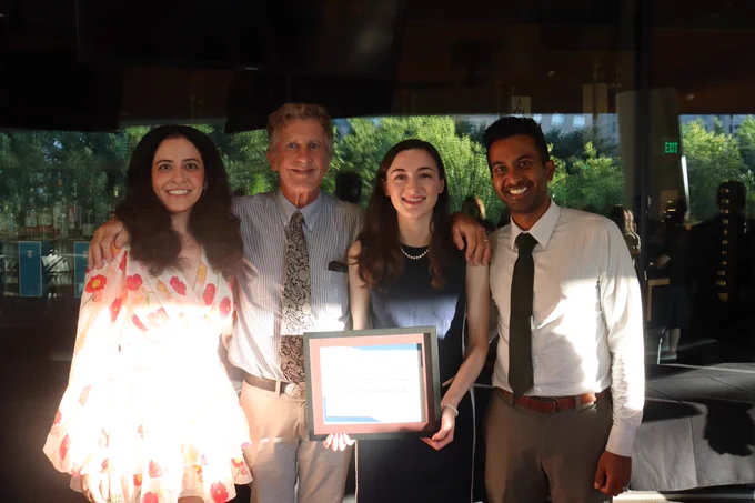 Gabrielle holding a certificate and standing with residency leadership.