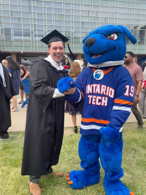 A photo of a graduate with Hunter the Ridgeback in Polonsky Commons.
