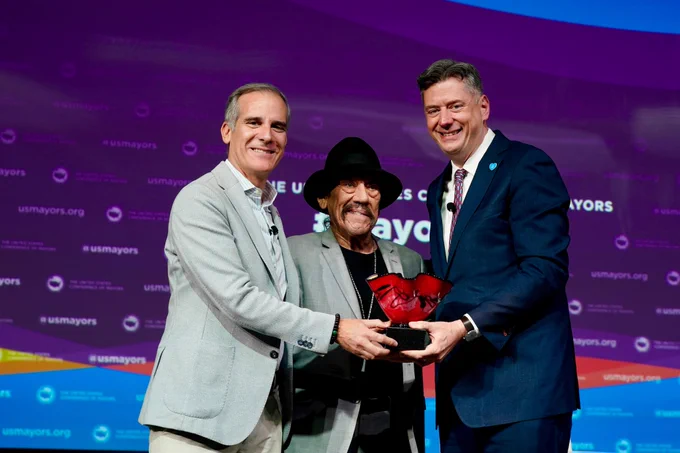 Former Los Angeles Mayor Eric Garcetti, Danny Trejo, and USCM President David Holt posing for a photo with the award.