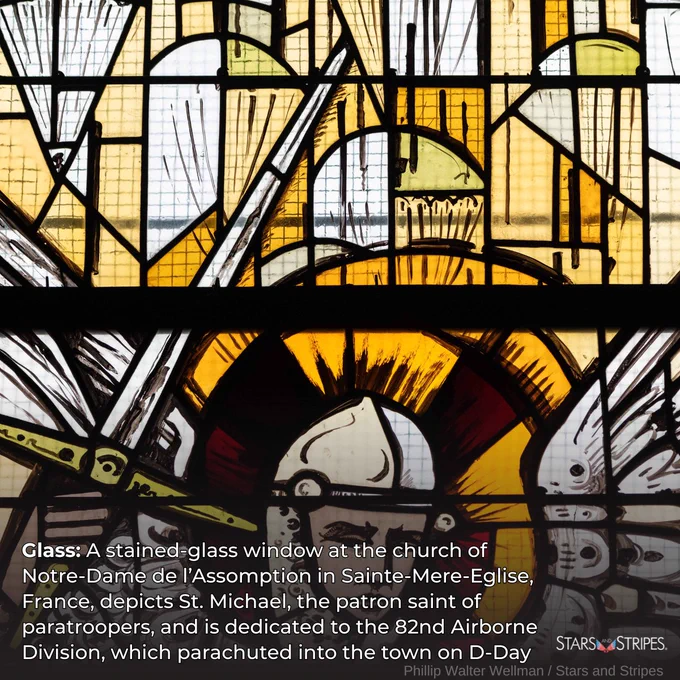 A stained glass window depicts St. Michael the archangel. Above his raised sword are parachutes. White text: Glass: A stained-glass window at the church of Notre-Dame de l'Assomption in Sainte-Mere-Eglise, France, depicts St. Michael, the patron saint of paratroopers, and is dedicated to the 82nd Airborne Division, which parachuted into the town of D-Day; Photo credit: Phillip Walter Wellman/Stars and Stripes; white Stars and Stripes logo