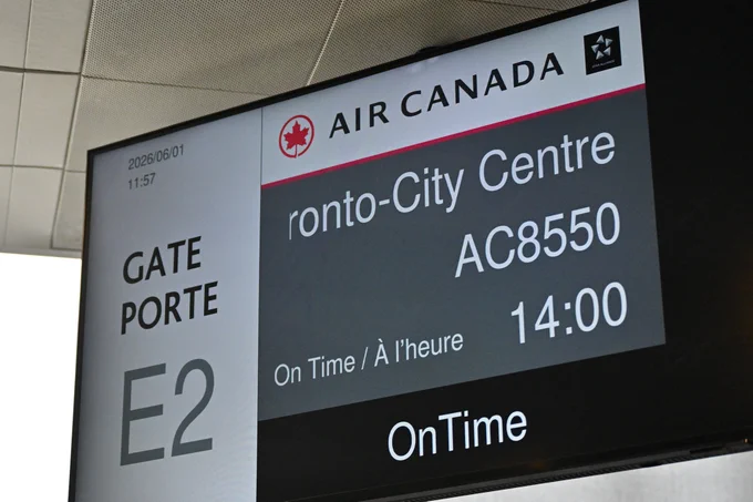 An airport departure screen displaying Air Canada flight information. The flight to Toronto City Centre, AC8550, is scheduled to depart from gate E2 at 14:00 and is currently on time.
