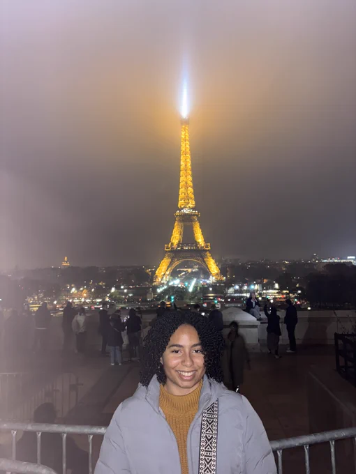 Elise smiles in front of the Eiffel Tower.