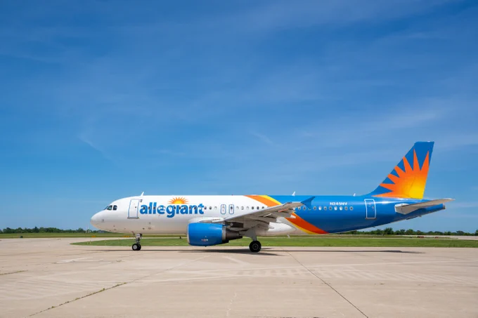 Allegiant Air passenger plane parked on a concrete runway under a clear blue sky.