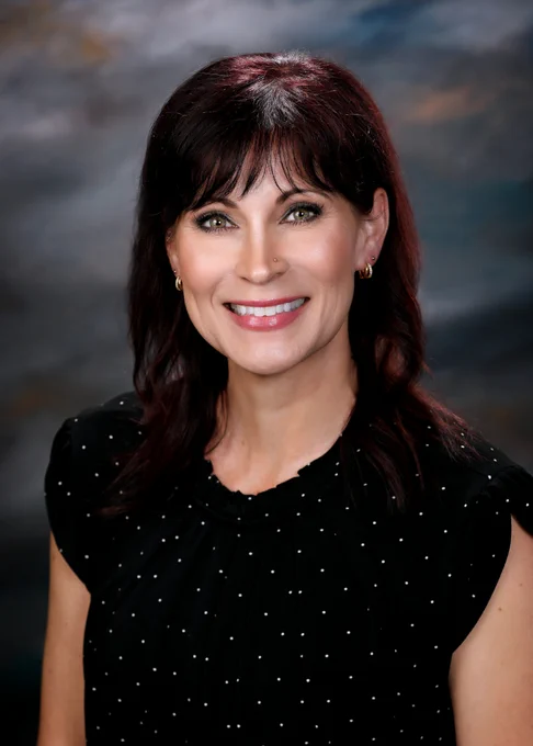 Professional person sitting for a portrait with a black background. 