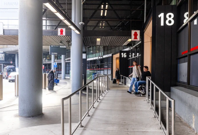 Airport terminal exterior with accessible ramp and entrances labeled 16 and 18.