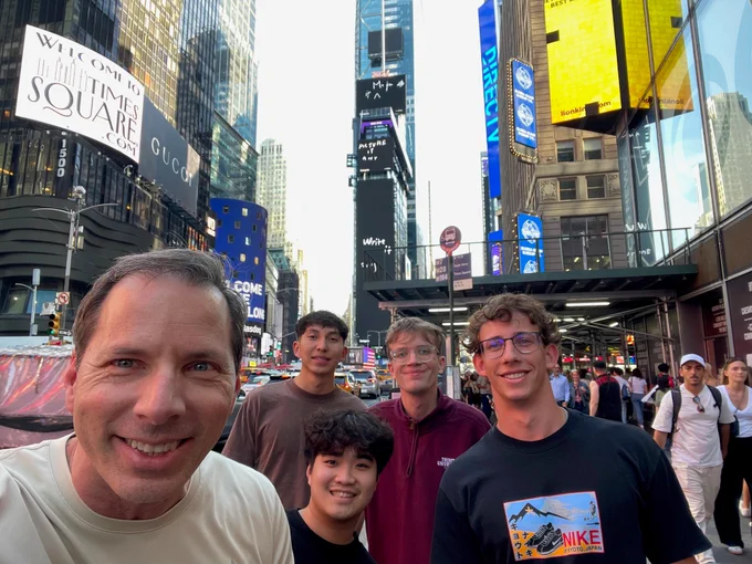 Five men take a selfie in Times Square.
