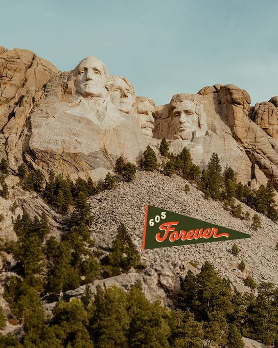 Mount Rushmore with its famous carved faces of historical figures. A vintage-style pennant in the foreground reads "605 Forever.