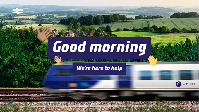 A train speeds through a scenic countryside landscape with rolling hills and fields. The image includes a sign saying "Good morning" and "We're here to help," featuring waving hand emojis. The Northern Rail logo is visible on the train.