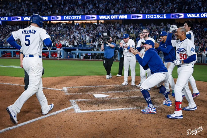 A photo of Freddie Freeman running towards his teammates at home plate after hitting a walk-ofd home run.