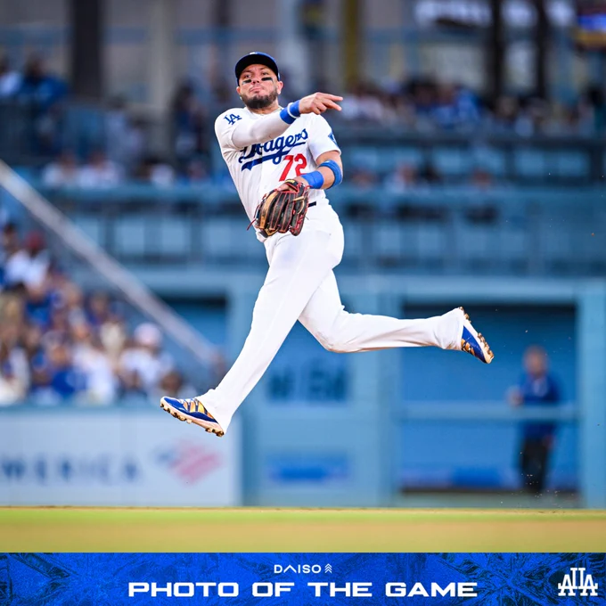 A photo of Miguel Rojas in the air while throwing to first base.
