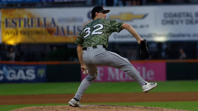 Kade Anderson pitching in a camo Arkansas Travelers jersey