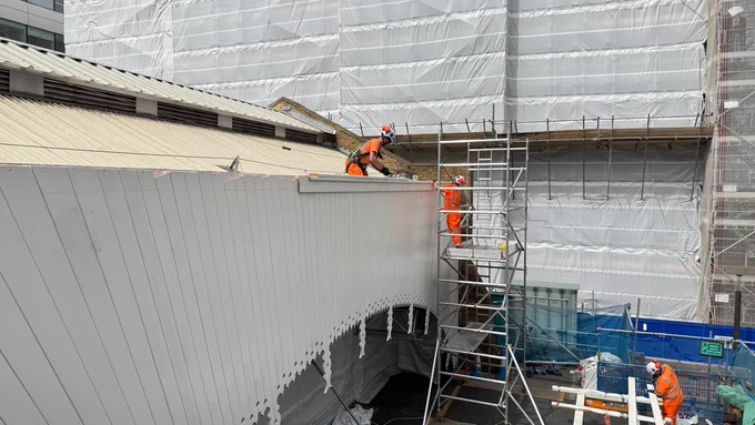 Engineers working on the valance, with a scaffolding tower in place.
