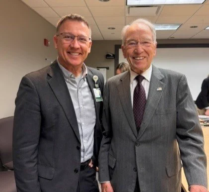 Two people standing together in suits. 