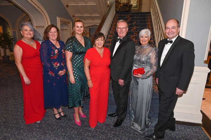 A group of 7 people standing in a line at the RCN Awards.