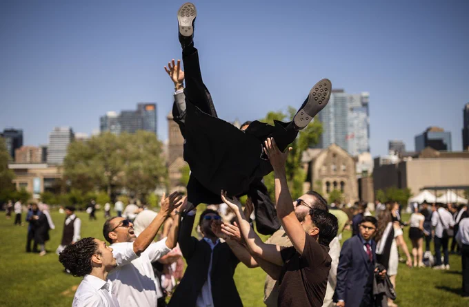 UTM graduate Omar Al Bakri is lifted into the air by family and friends following a convocation ceremony at the University of Toronto. 

