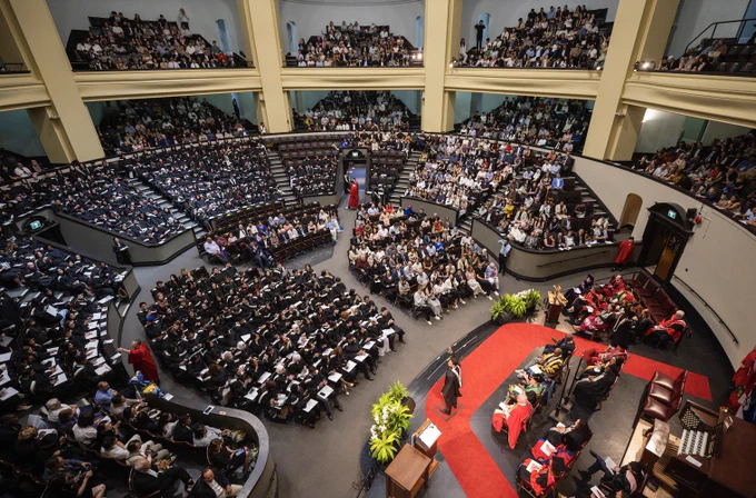 U of T Convocation Hall is filled with many people attending a UTM graduation ceremony. 
