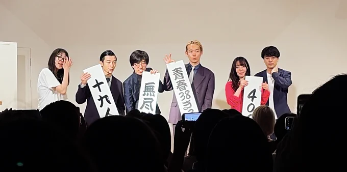 右からコンビ名の垂れ幕を持った4000の2人、無尽蔵の2人、十九人の2人