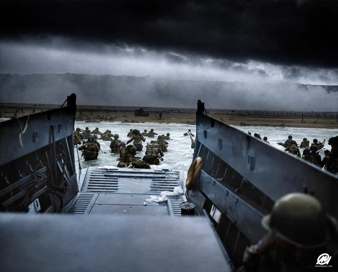 Landing craft ramp is lowered on a stormy beach during WWII, revealing soldiers wading towards the shore under a menacing, cloudy sky on D-Day, 1944.