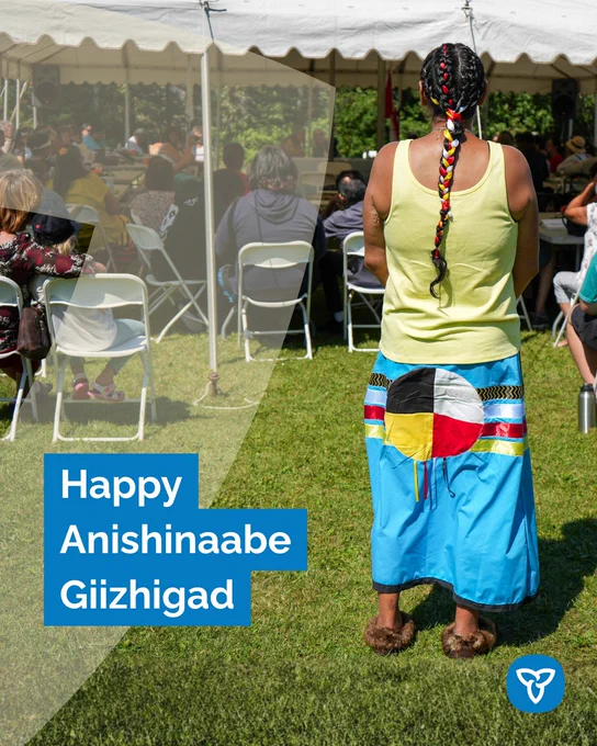 Copy: Happy Anishinabek  Giizhigad
Alt text: Photo of Indigenous woman wearing a ribbon skirt with a Medicine Wheel design