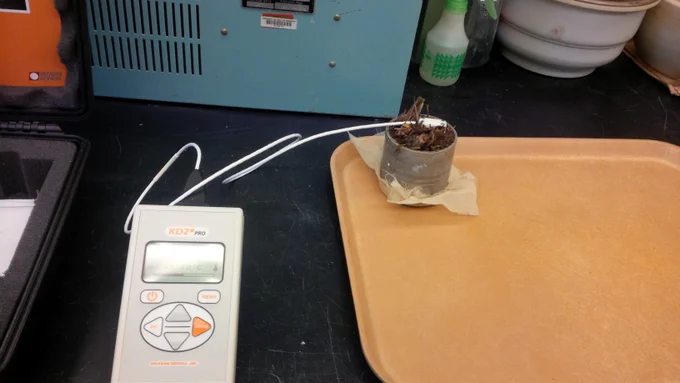After the soil samples were collected from the farm, they were processed in the lab. A KD2 Pro heat-pulse sensor (Decagon devices, Pullman, WA) was used to determine the thermal conductivity, volumetric heat capacity, and thermal diffusivity at each soil water pressure (0, −33, and −100 kPa). Shown, a sample core in the lab being analyzed using the KD2 Pro heat-pulse sensor.   