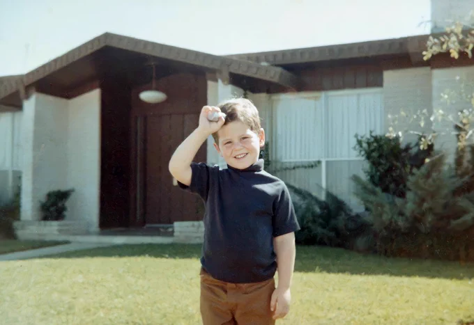 young Michael Dell smiling and standing.