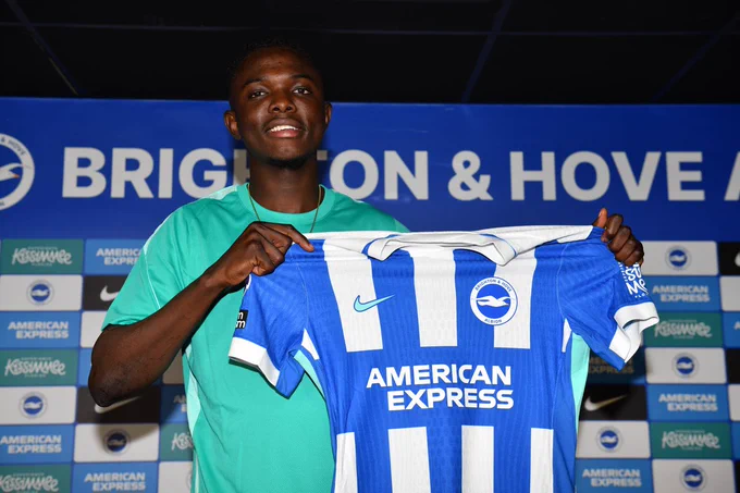 Zadok Yohanna smiles whilst holding the BHAFC home shirt. 