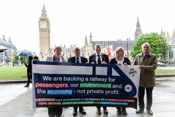 Pictires of MPs carrying a banner supporting rail reforms to protect passengers’ rights, the environment and the economy.