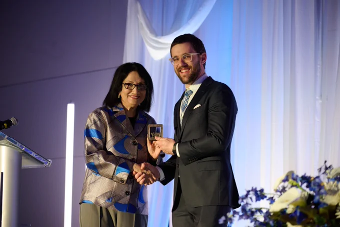 Matthew Kapelewski accepting the 2026 Alumni Achievement Award from Penn State President Neeli Bendapudi.
