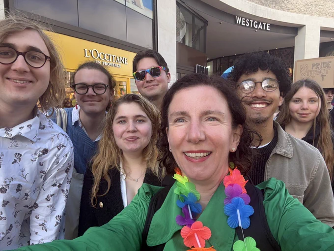 Anneliese stood with a group of people smiling, taking a selfie.