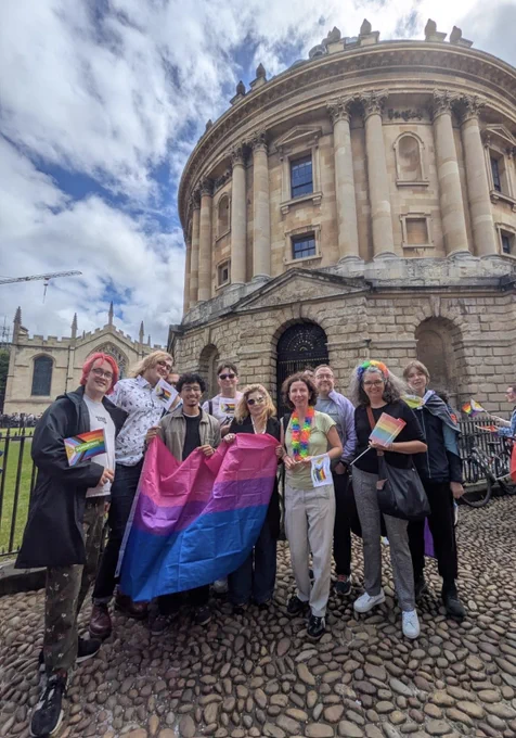 Anneliese with a group of people with many with colourful flags and banners in front of the rad cam.