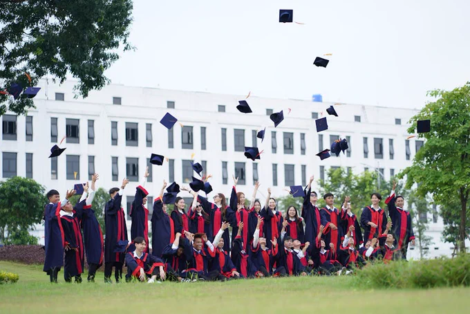 A group of graduates in Vietnam celebrate by throwing caps into the air.