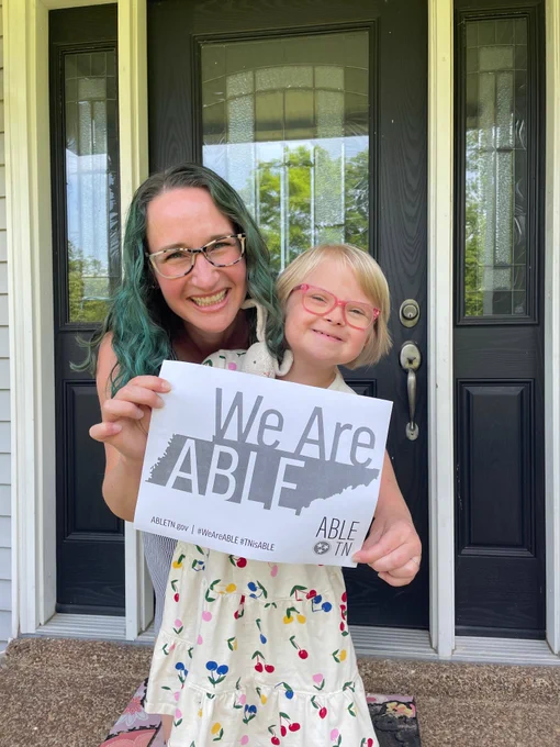 ABLE TN saver with family member holding a sign that says “We are ABLE” with ABLE TN branding. 