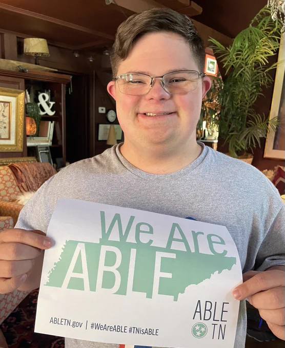 ABLE TN saver, Houston Vandergriff holding a sign that says “We are ABLE” with ABLE TN branding.