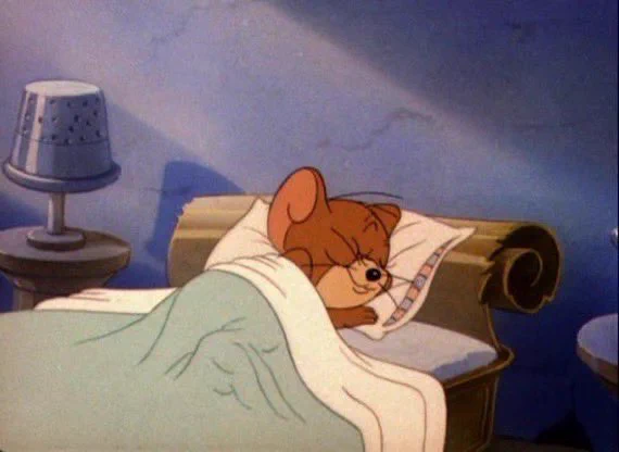 Picture of Jerry the mouse from the TV cartoon “Tom & Jerry” sleeping in bed with a smile on his face.