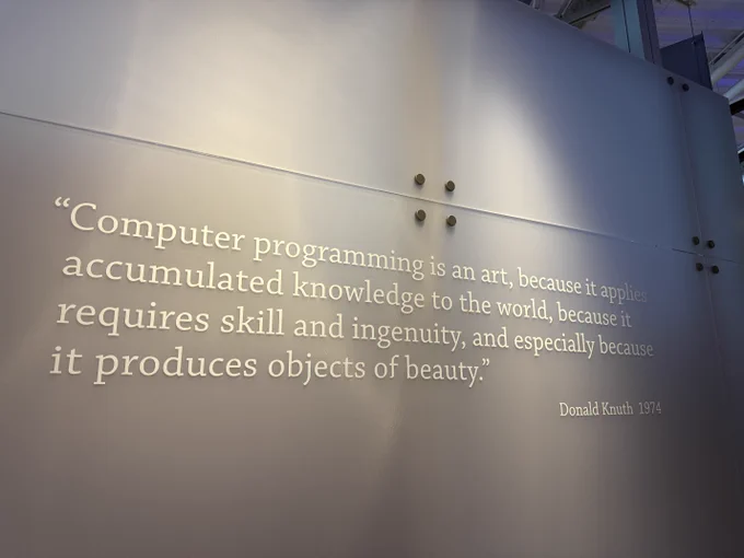 A wall displays a quote by Donald Knuth emphasizing computer programming as an art that showcases skill and beauty.