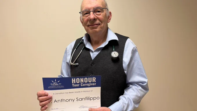 Dr. Anthony Sanfilippo smiling and holding an Honour Your Caregiver certificate with his name on it.