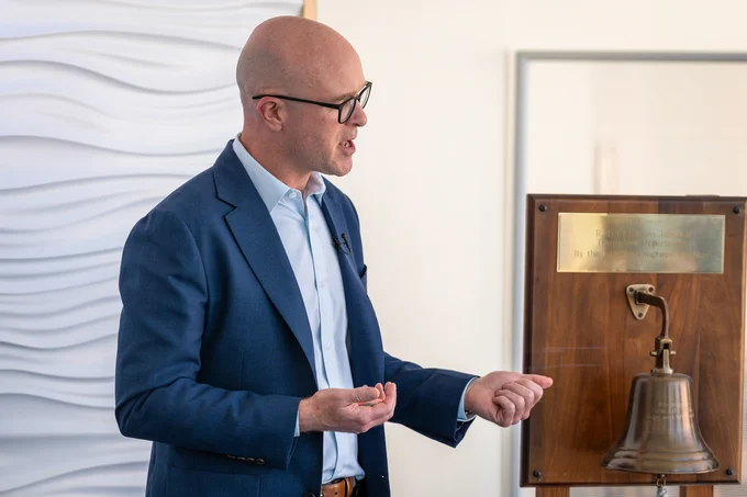 A person standing next to a bell talking
