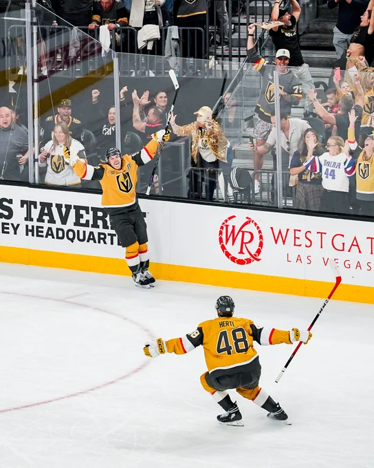 Mitch Marner and Tomas Hertl celebrating a goal on ice in Golden Knights uniforms. 