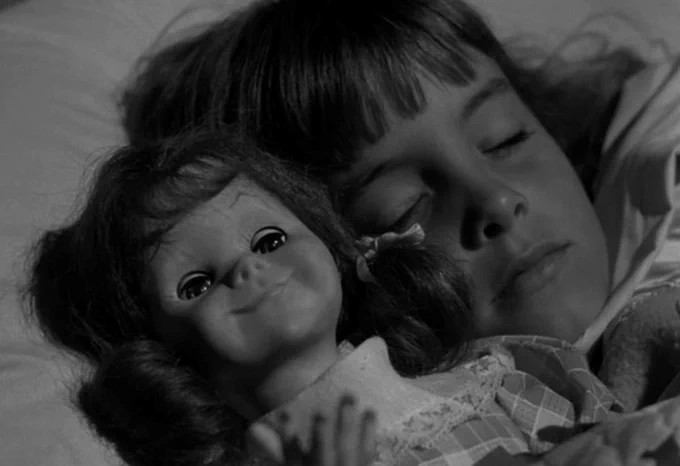 A girl sleeping with her doll "Talking Tina" in Living Doll (The Twilight Zone season 5, episode 6, broadcast on November 1, 1963)